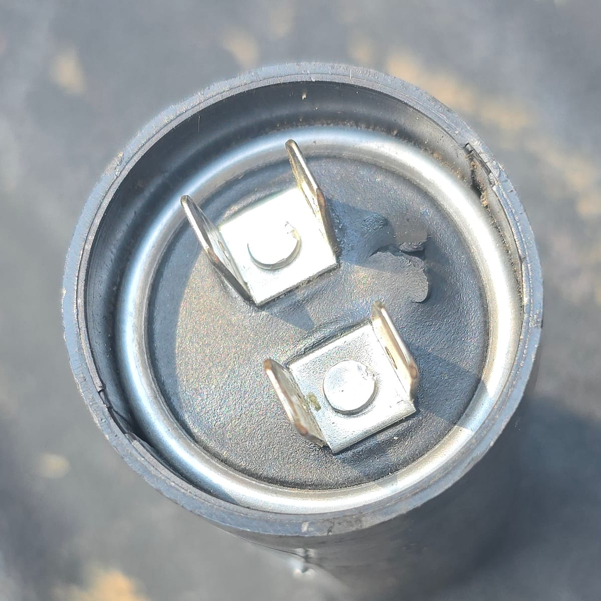 Hole in the top of a failed garage door opener capacitor