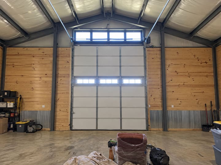 Inside of a tall garage door after StraightShot Overhead installed white vinyl-backed insulation panels on every section