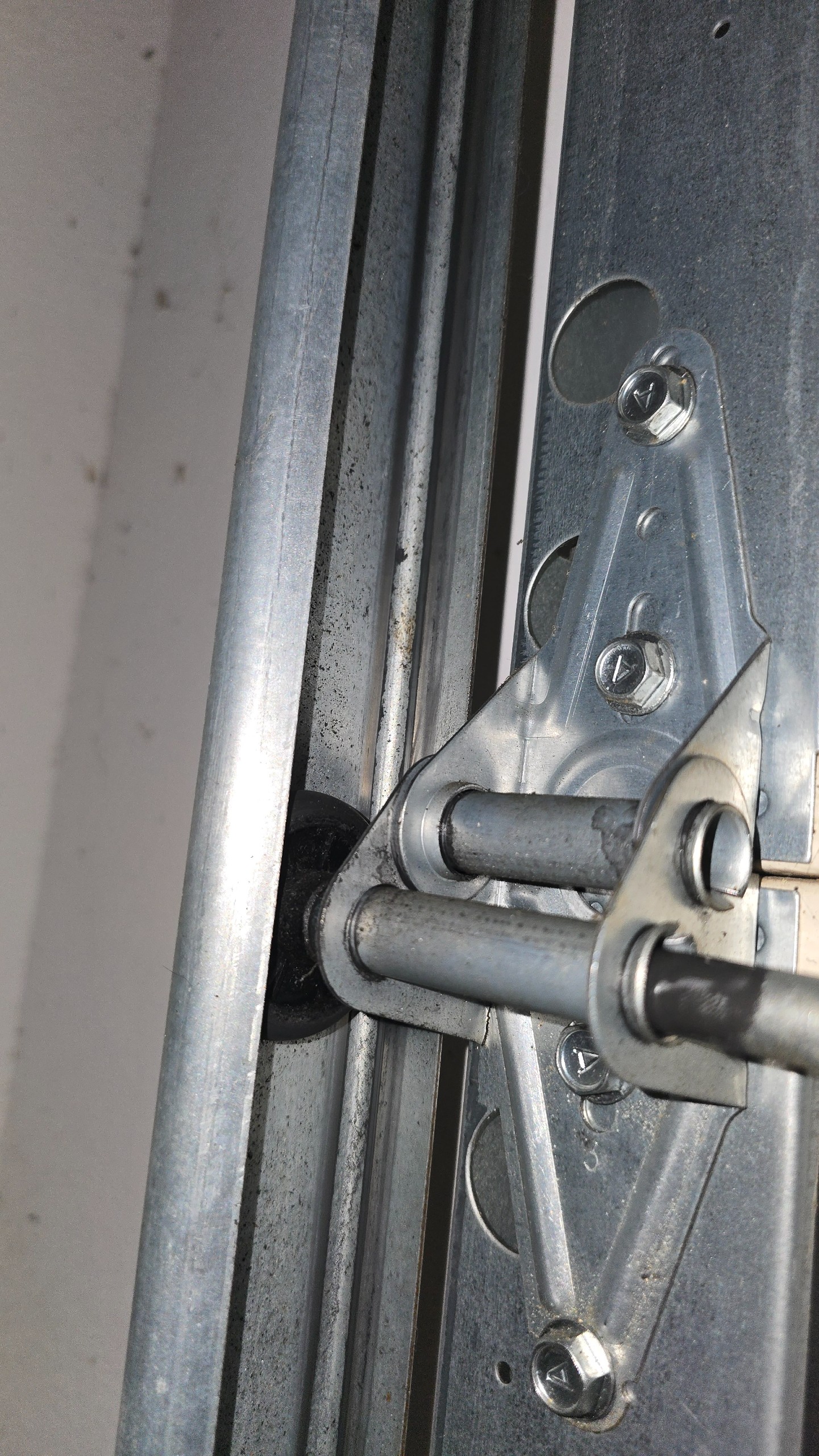 Original nylon-bushing roller seated in the garage door track in Tyler, TX