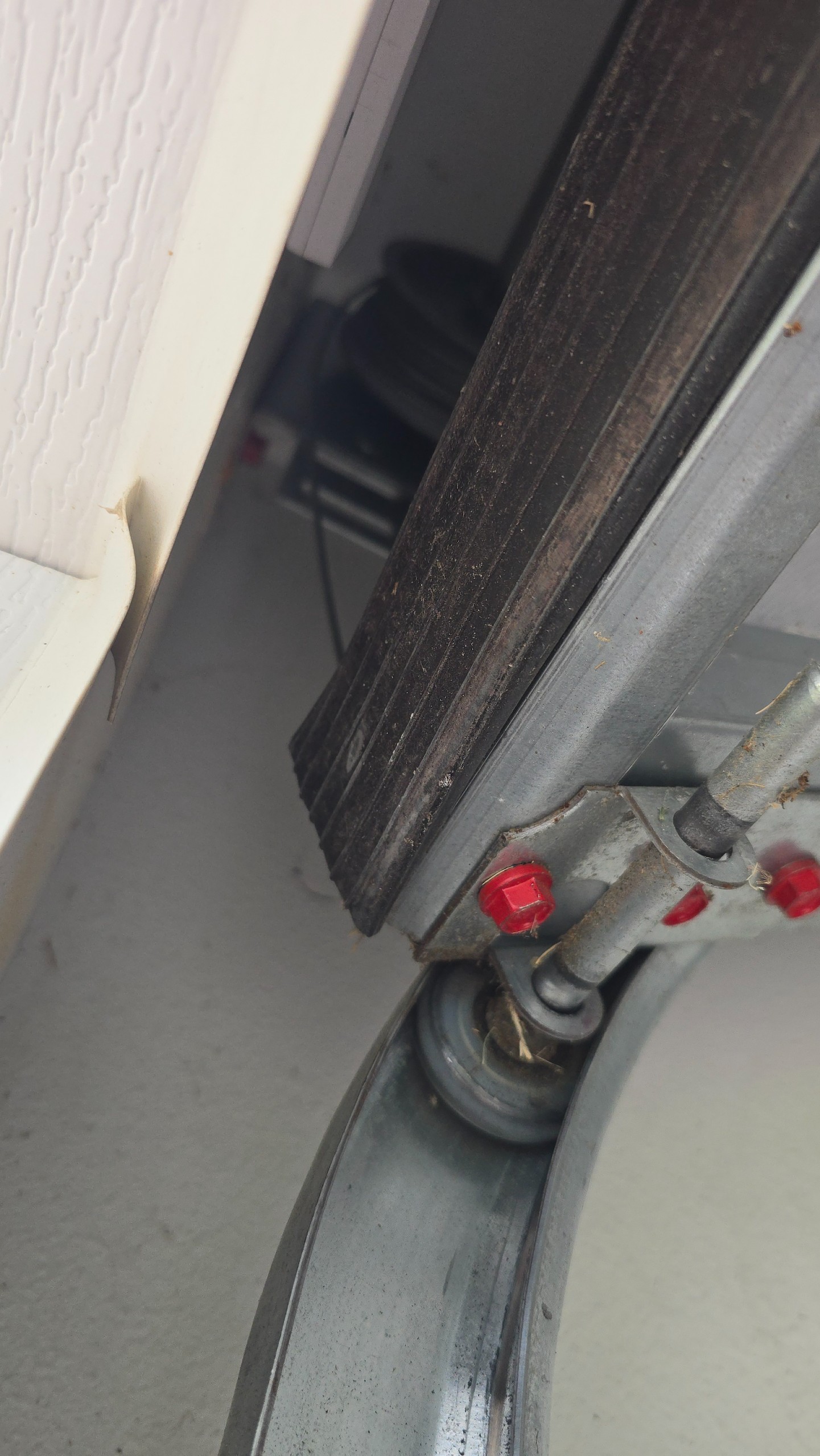 Closer view of the bottom roller, bracket, and garage door track in Tyler, TX